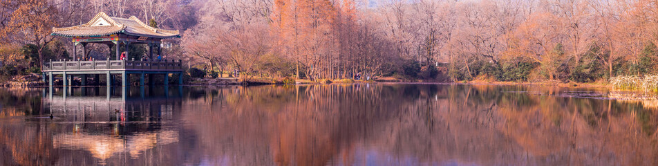 NANJING, CHINA, DECEMBER 25, 2015: The summer pavilion with water reflection on a small lake in the Purple Mountain park in Nanjing, China, 2015.