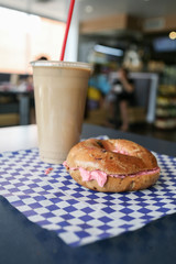 bagel with strawberry cream cheese and iced coffee