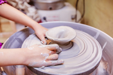 Fototapeta na wymiar young potter hands working with clay on pottery wheel