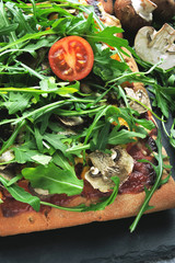 Vegan pizza with mushrooms and fresh arugula. Square pizza with vegetables, mushrooms and arugula.