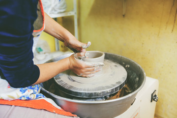 young potter hands working with clay on pottery wheel