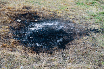 Traces of ash and charcoal grill  after a barbeque  fire in nature during   summer
