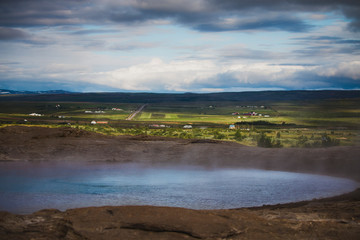 The colorful geyser landscape at the Haukadalur geothermal area at summer season