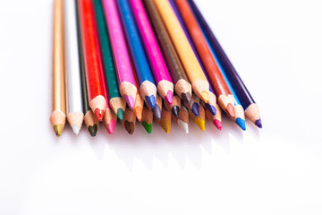 Colorful pencils for drawing lie on a light background