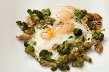 Fried eggs with broccoli and chicken meat. Healthy breakfast.