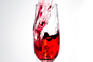 Pouring red wine isolated on white
