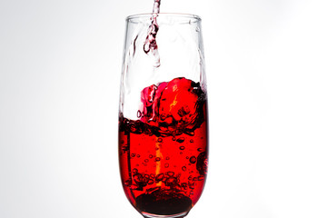 Pouring red wine isolated on white