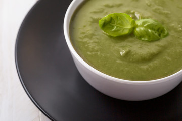 Green cream soup of spinach and chickpeas on concrete wood background