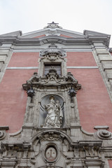Fototapeta na wymiar Ancient statue on front of classic brick building with elaborate trim