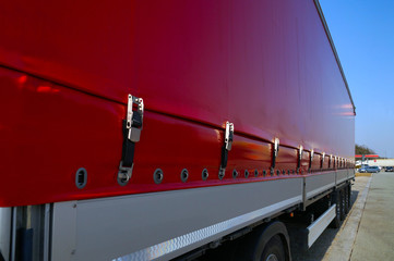 Semi-trailer with covered tarpaulin before unloading. Transport and unloading.