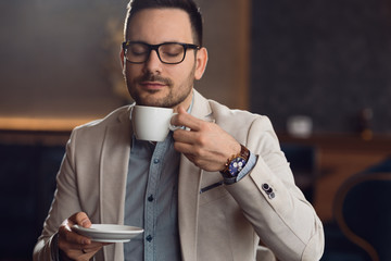 Businessman enjoying in a smell of fresh coffee.