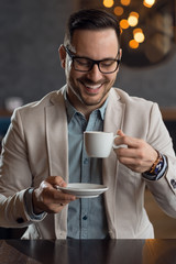 Happy mid adult businessman drinking coffee while relaxing in a cafe