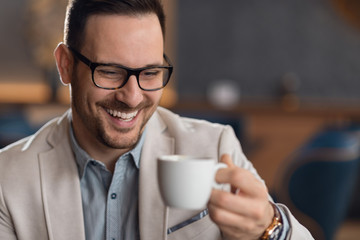 Happy mid adult businessman drinking coffee while relaxing in a cafe