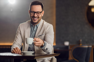 Happy mid adult businessman drinking coffee while relaxing in a cafe