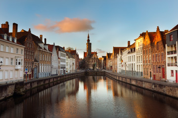 Naklejka na ściany i meble Brugge evening cityscape. Old buildings at water channel in Bruges, Belgium