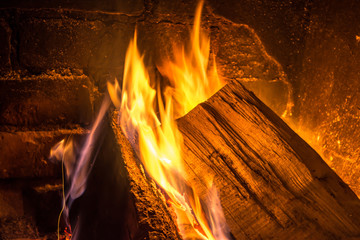 Firewood burning in an old fireplace close up