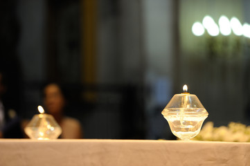 dos velas en lámparas de cristal sobre una mesa en una iglesia