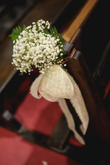 Adorno floral en asientos en una iglesia durante un boda