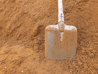 A shovel in construction sand with copy space