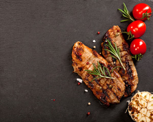 Grilled beef steak on with spices on black background