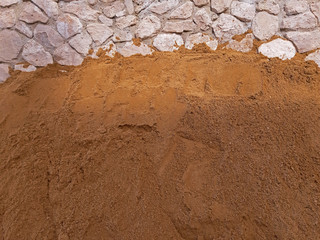 A lot of Construction sand near a wall background