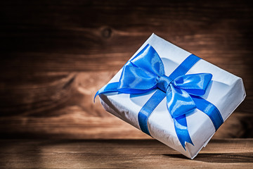 giftbox with blue ribbon on vintage wood
