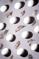 Easter background. Easter egg composition of white eggs and feathers.