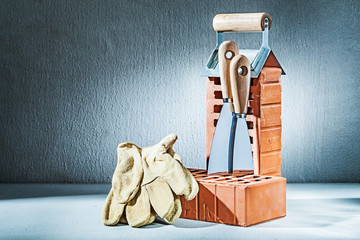 gloves bricks and trowels on concrette background