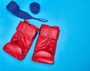 a pair of red leather boxing gloves and a textile bandage