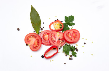 Sliced fresh tomatoes, bell peppers, seasonings and greens, isolated on white background. top view.