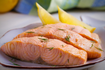 Cooked on steam salmon steaks with lemon. Dietary menu. White plate on white table. horizontal