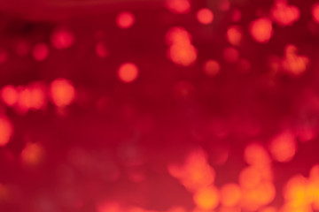 Abstract red background in blur. Lights and spots defocus.