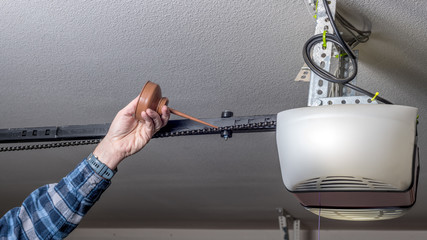 Metal oil can is used to apply some fresh oil to a garage door opener chain