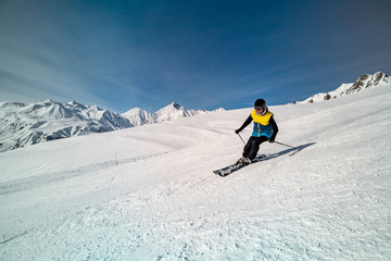 Male skier skiing on ski slope on a sunny winter day at the ski resort Gudauri in Georgia