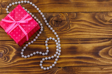 Fototapeta na wymiar Gift box and pearl necklace on wooden background