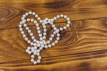Pearl necklace on wooden background. Top view