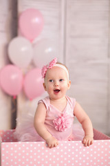 Fototapeta na wymiar happy little year old girl in pink tutu skirt and leggings with balloons