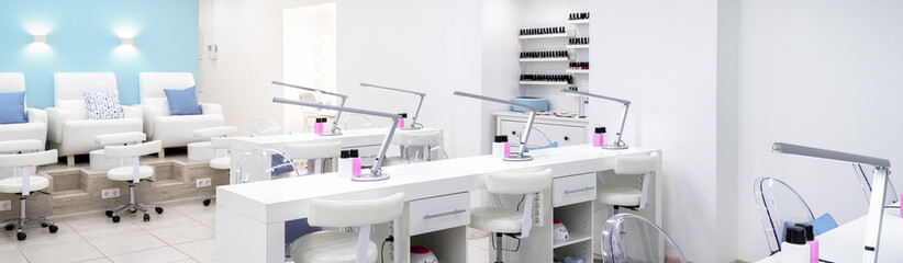Nail salon bright interior. Panoramic view of modern manicure salon. Horizontal banner with spa room. Inside beauty studio with white design. - obrazy, fototapety, plakaty