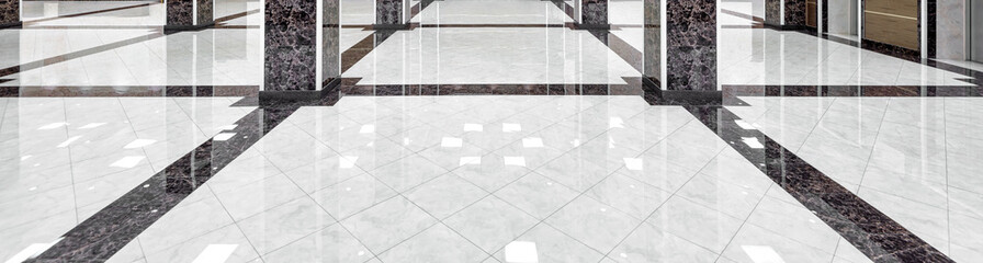 Marble floor of luxury lobby of company or hotel. Panorama of cleaned washed floor in corporate hallway. Shiny floor with reflections after professional cleaning. Care service of office interior. 