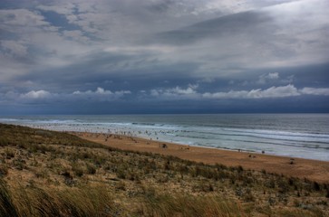 Fototapeta na wymiar Wolken am Meer mit Dünen und Strand