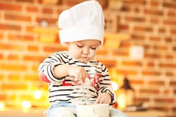 A portrait of cute kid cooked and played with flour and dough in the kitchen