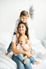 Fototapeta na wymiar happy loving family. mother playing with her children in the bedroom