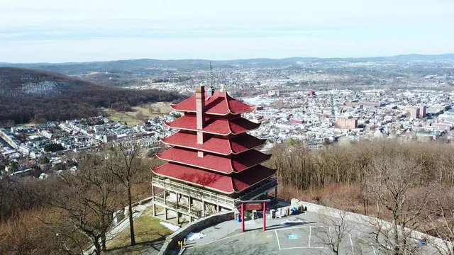 Aerial over Reading Pennsylvania Asian temple and American flag with city background.