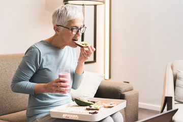 Mature woman eating breakfast