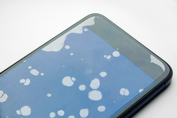 Protective film attached on the smartphone with dust on the screen. Many air bubbles between the...