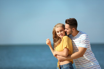 Happy young couple at beach on sunny day