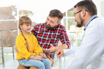 Obraz premium Little girl with father visiting children's doctor in hospital