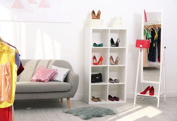 Shelving unit with shoes and purses in stylish dressing room interior