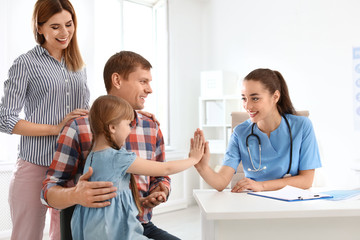 Parents with little daughter visiting children's doctor in hospital