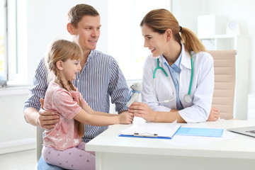 Fototapeta premium Little girl with parent visiting children's doctor in hospital